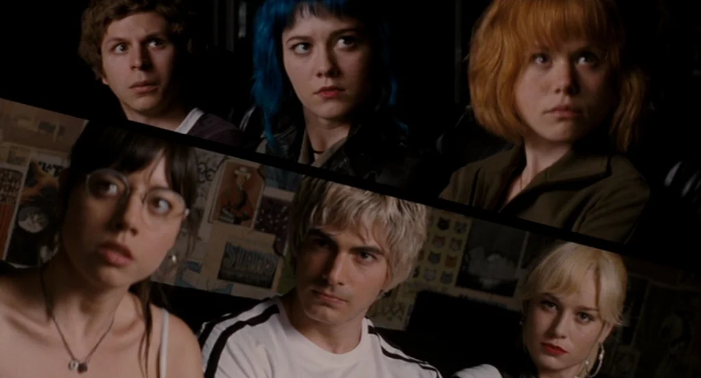 Scott Pilgrim Vs The World (2010) movie still: medium — Six young adults are seated in a dark movie theater with posters visible behind. They stare…