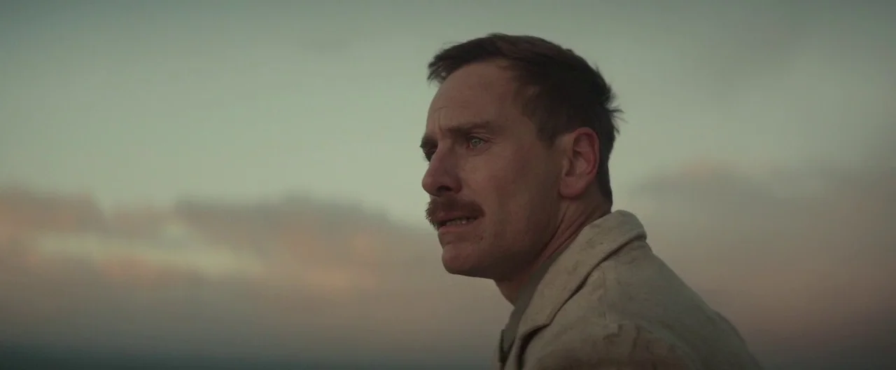 The Light Between Oceans (2016) movie still: closeup — An open coastal expanse during the fading light of dusk at the sea edge. A man in a…