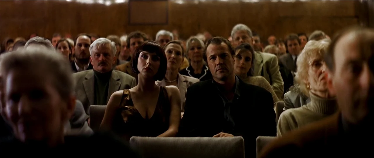 The Lives of Others (2006) movie still: medium — A dark auditorium with rows of padded seats filled with an audience. The people face forward while…