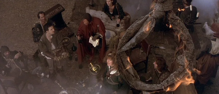 Flesh+Blood (1985) movie still: wide — A stone-floored room is filled with haze and centered around a large iron brazier. Several people in period…