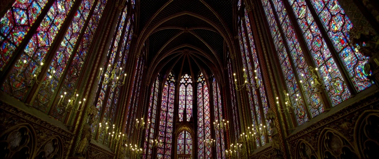 Samsara (2011) movie still: establishing — A tall, vaulted cathedral interior features soaring walls composed almost entirely of intricate stained…