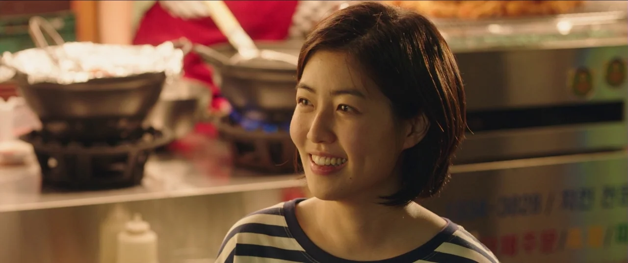 Psychokinesis (2018) movie still: medium — A food preparation area features metallic equipment and cooking pots under warm lights. A young woman…