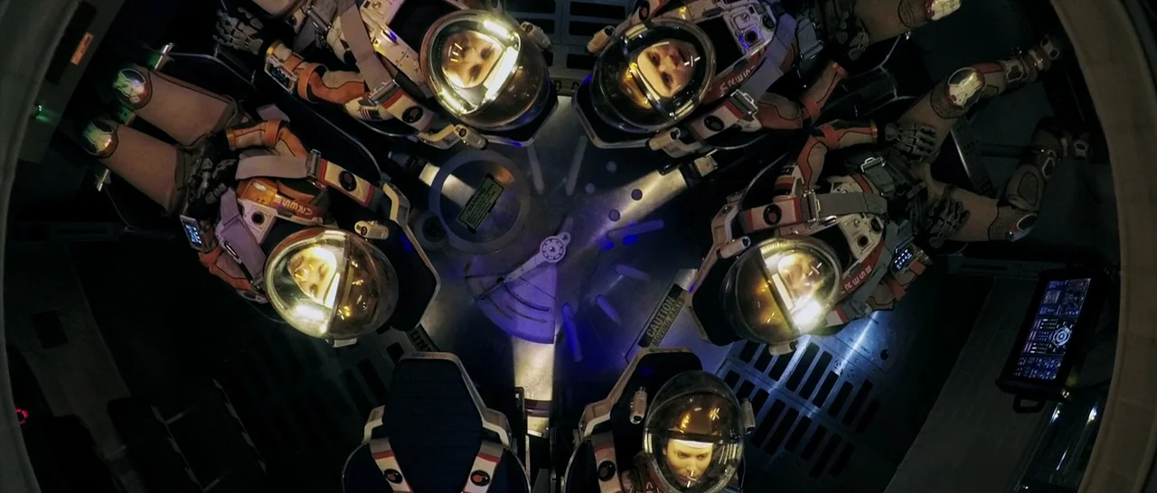 The Martian (2015) movie still: wide — A high-tech spacecraft interior features five crew members seated in a circular formation. Each astronaut…