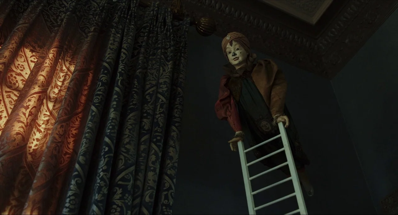Knives Out (2019) movie still: medium — An ornate interior features heavy patterned curtains near a ceiling with decorative crown molding. A vintage…