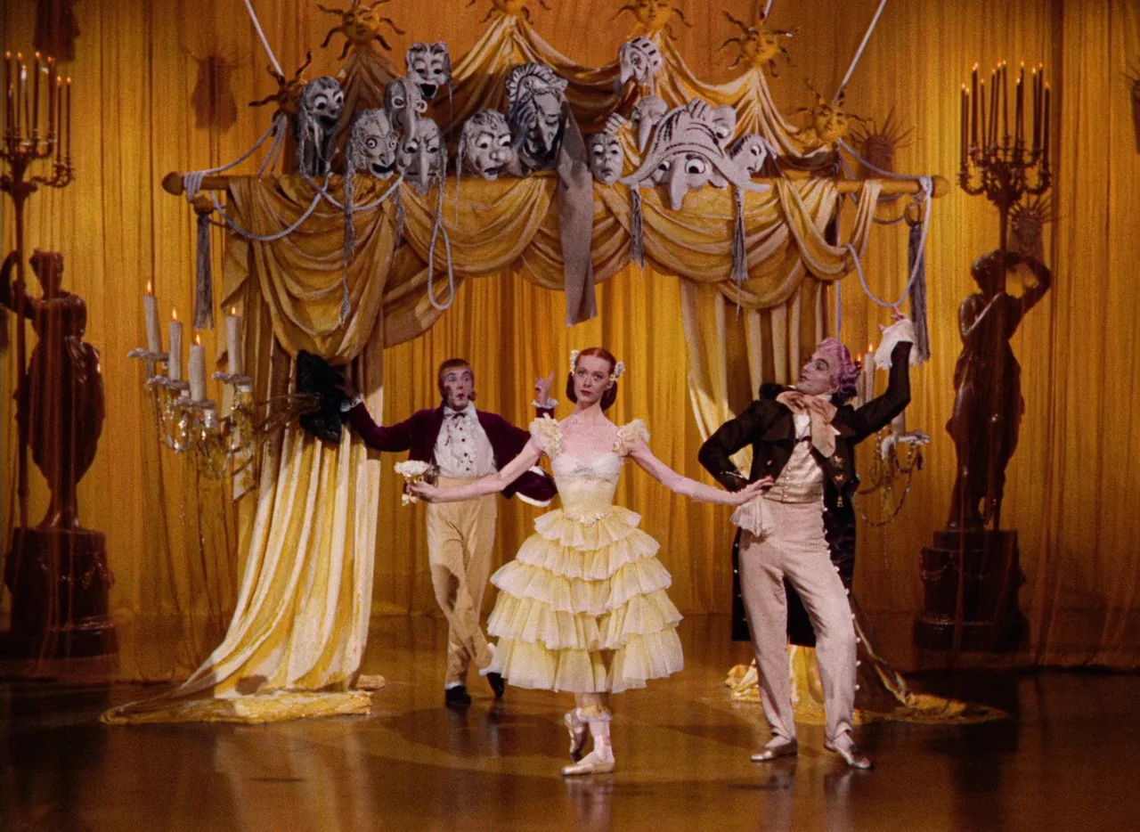 The Tales of Hoffmann (1951) movie still: fullbody — A theatrical stage setup features draped yellow curtains and multiple white grotesque…
