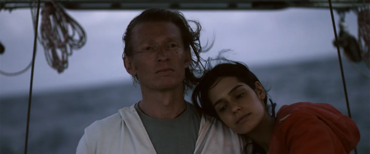 Dirty Little Secret (1998) movie still: medium — A man and woman stand on the deck of a boat at dusk. The woman rests her head on the man's shoulder…