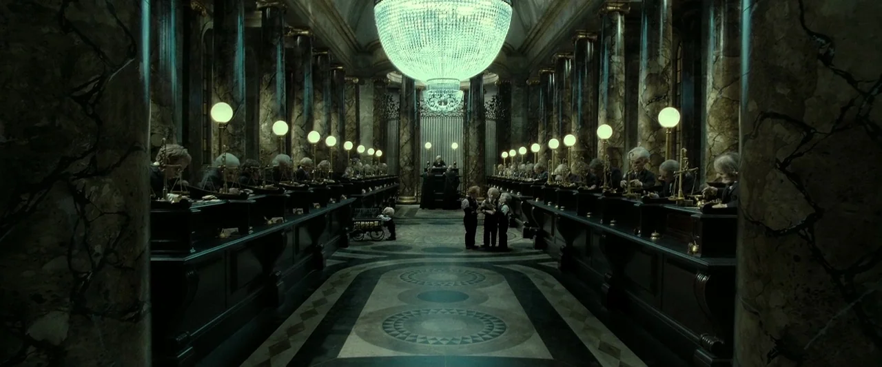 Harry Potter & The Deathly Hallows Part 2 (2011) movie still: wide — A long, cavernous bank hall features rows of marble pillars and dark wooden…