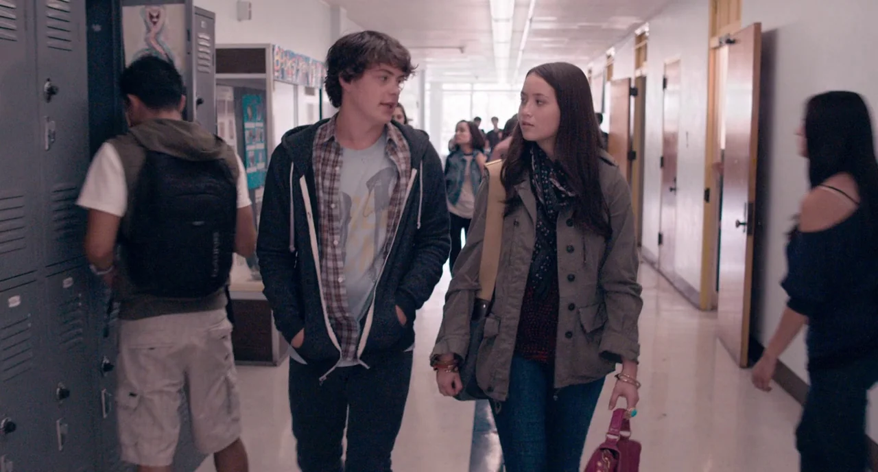The Bling Ring (2013) movie still: medium — A high school corridor features rows of grey metal lockers and light-colored walls. A young couple walks…