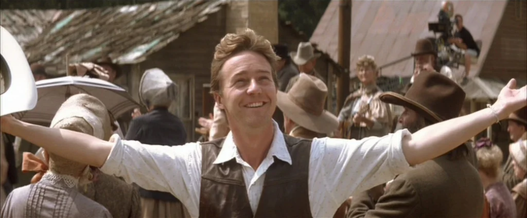 Down In The Valley (2005) movie still: medium — A bustling 19th-century settlement scene features wooden buildings and people dressed in…
