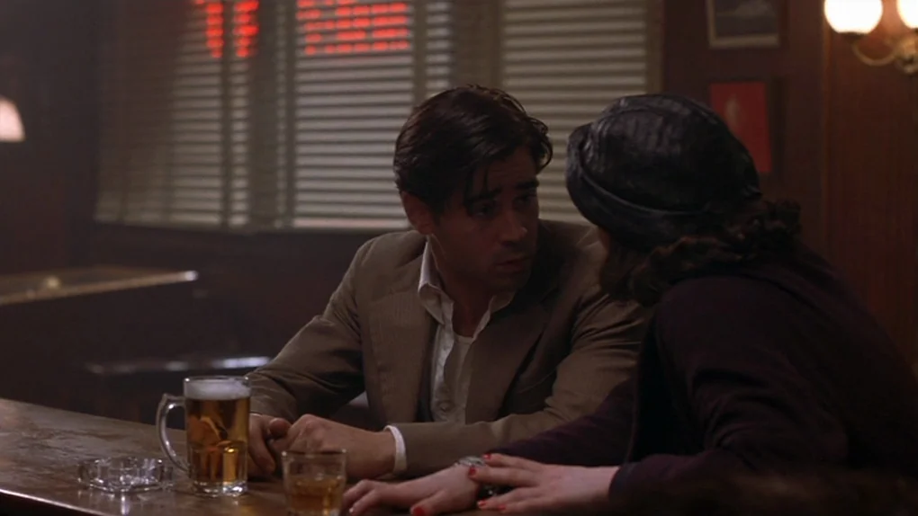 Ask The Dust (2006) movie still: medium — A dark wooden bar interior with horizontal blinds covering a window in the background. A man and woman sit…