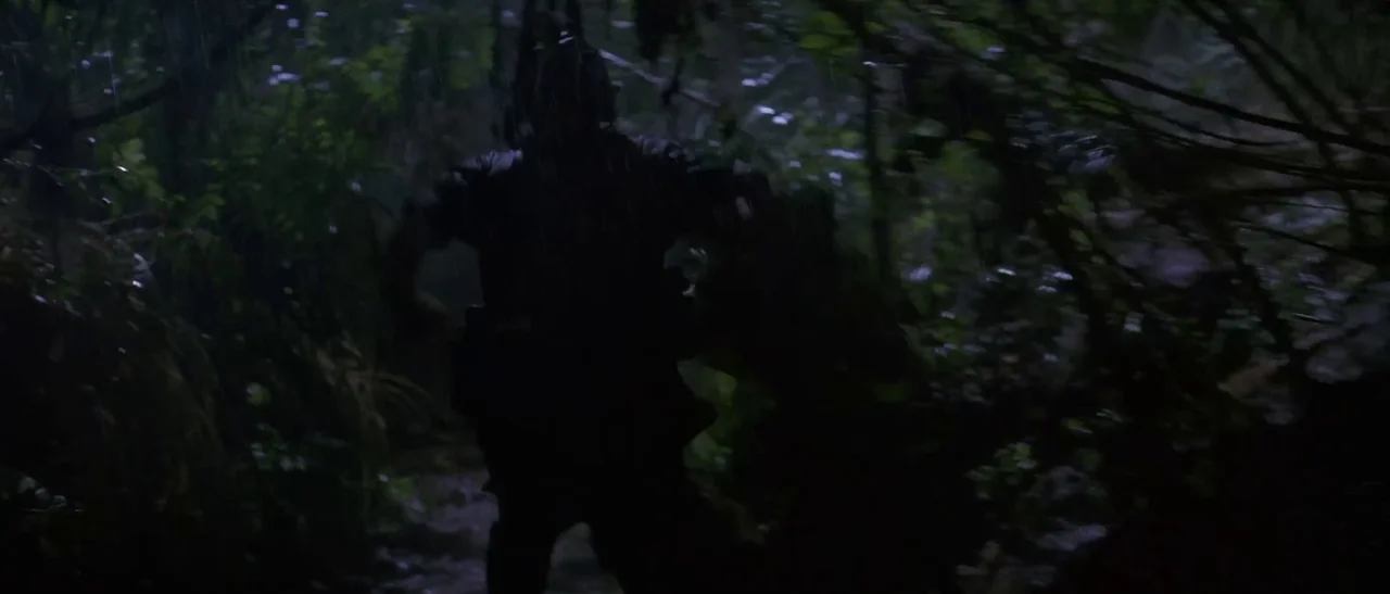 Universal Soldier (1992) movie still: fullbody — A dense, rain-slicked jungle environment during a storm with heavy foliage. A person runs away from…