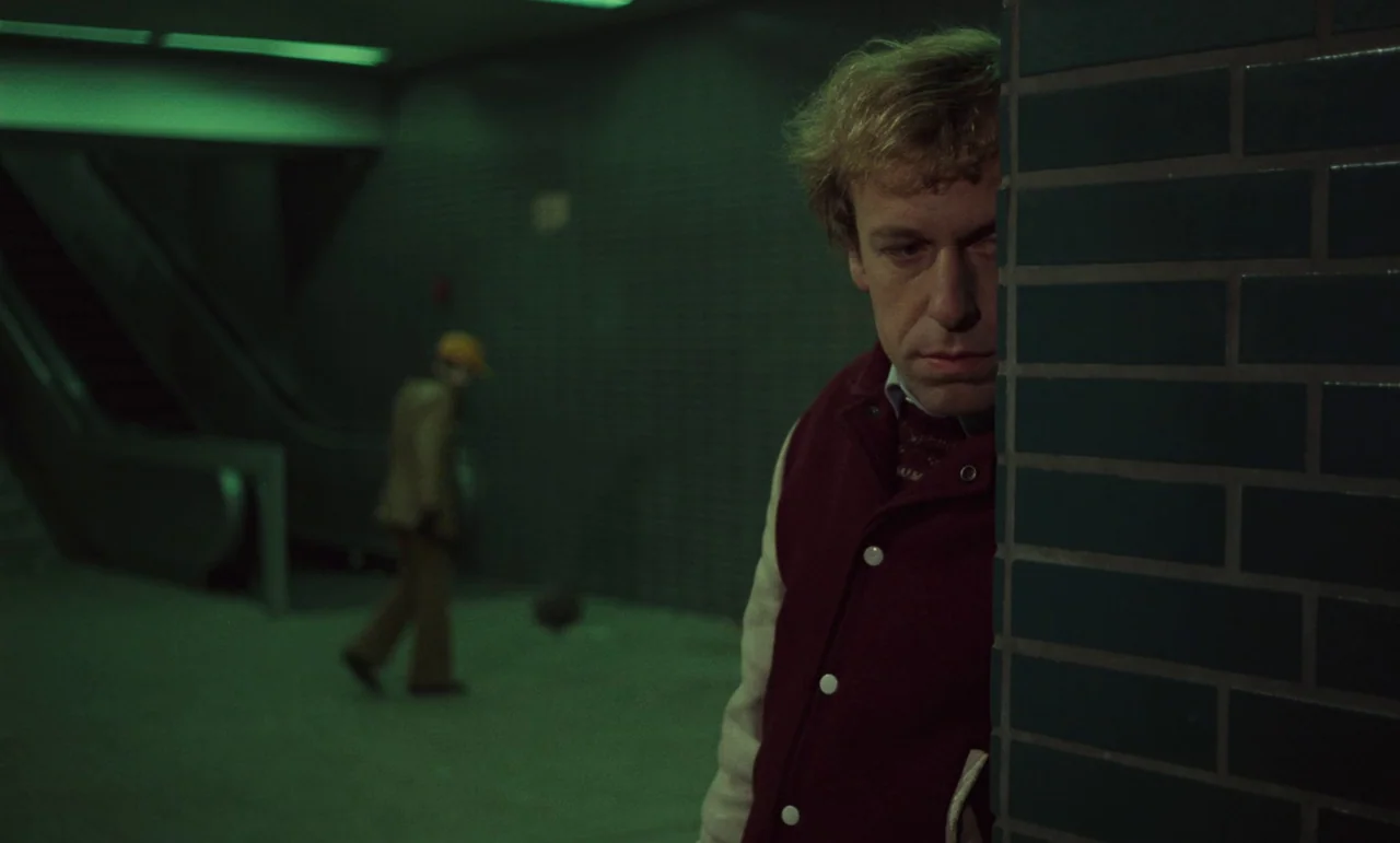 Wrong Move (1975) movie still: medium — A dimly lit tiled corridor within a subterranean public transport station. A man watches another figure walk…