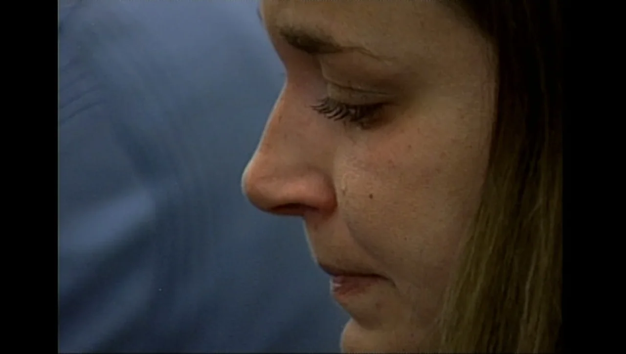 The Trials of Ted Haggard (2009) movie still: closeup — The frame shows the side profile of a young woman's face against a dark blue background. The…
