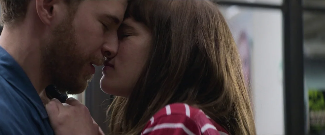 Crazy About Her (2021) movie still: closeup — Two individuals stand closely together with foreheads touching in an indoor space. The woman grips the…