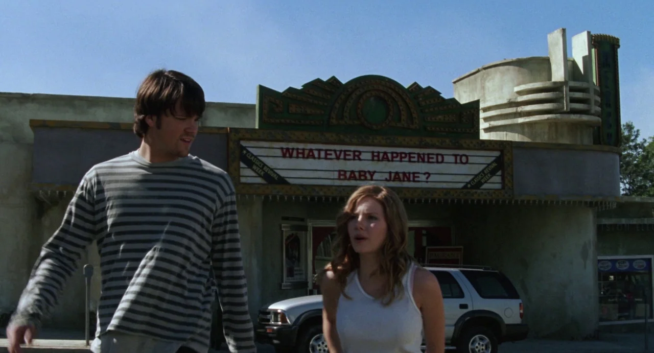 House of Wax (2005) movie still: medium — A man and woman walk in front of a vintage art deco style cinema. The marquee displays the title of the…
