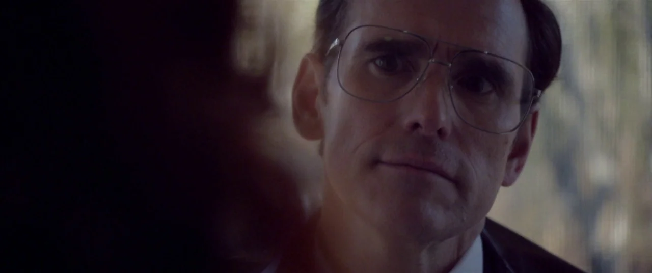 The House That Jack Built (2018) movie still: closeup — The interior of a vehicle with blurred foliage visible through the side window. A…