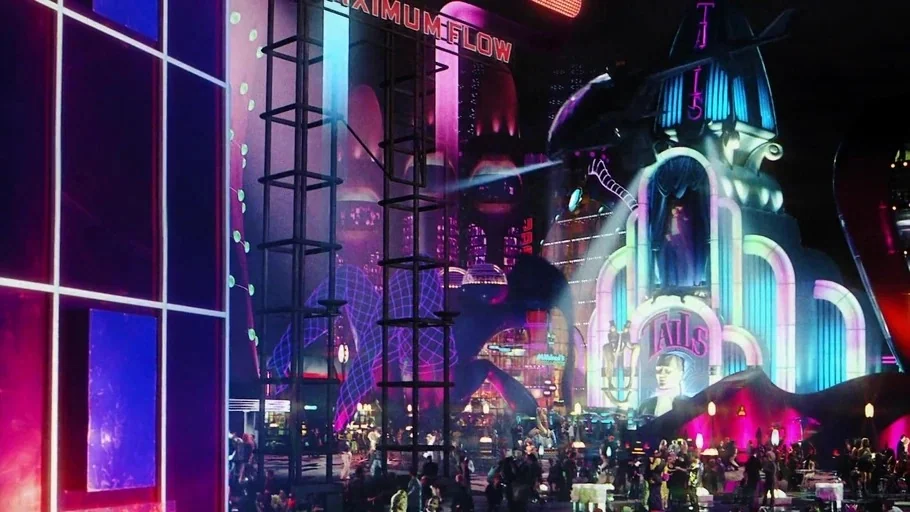 A.I. Artificial Intelligence (2001) movie still: establishing — A bustling urban plaza at night features towering, art-deco-inspired structures with…