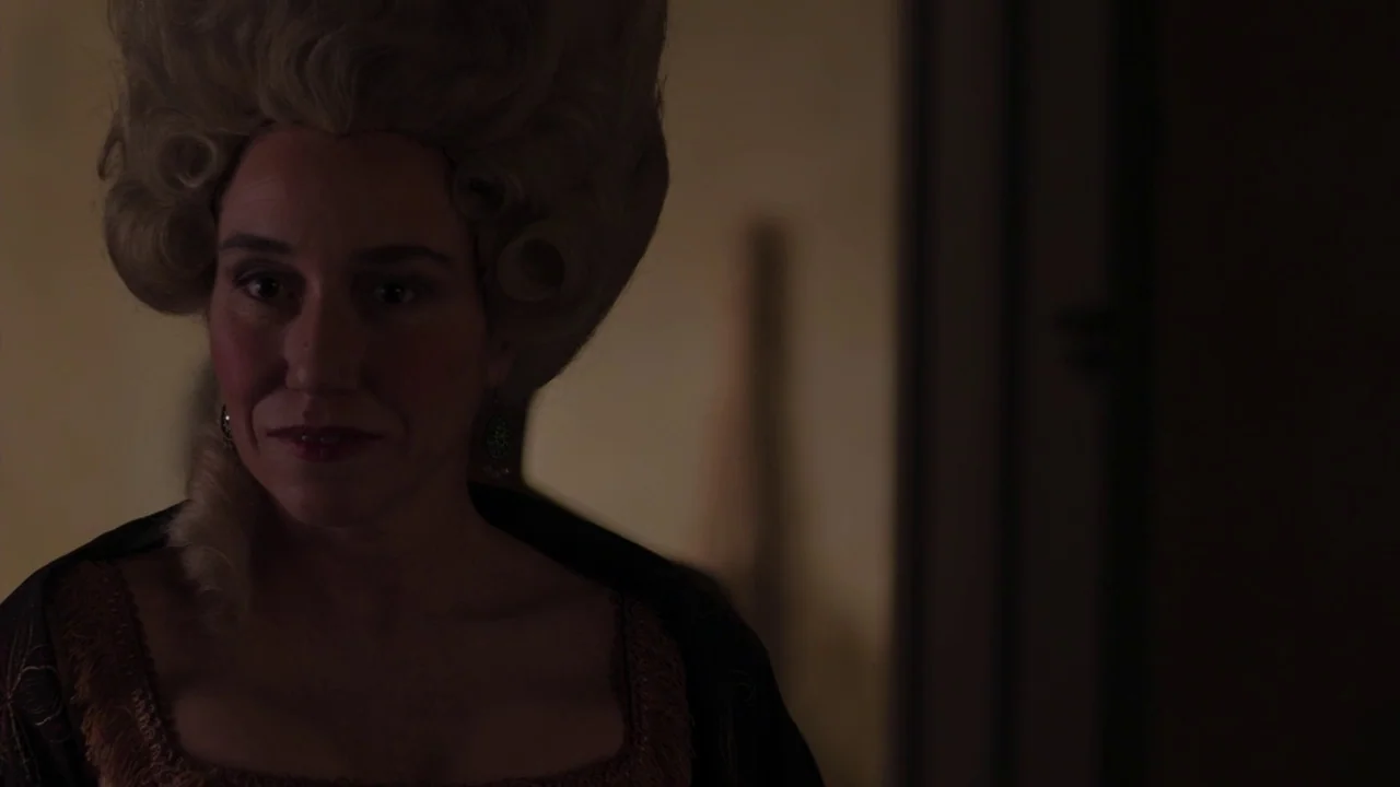 Zama (2017) movie still: medium — A dimly lit interior space with shadows obscuring the surrounding architecture. A woman wears a large historical…