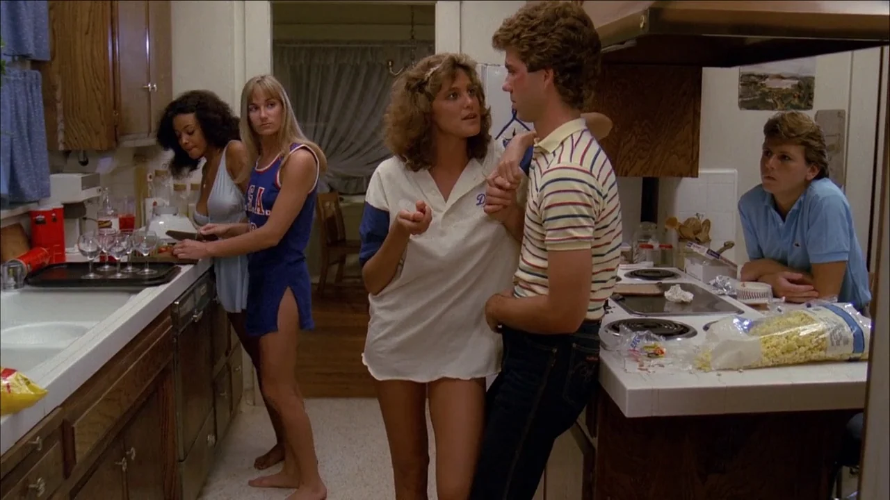 The Slumber Party Massacre (1982) movie still: medium — An 1980s residential kitchen features white appliances, light-colored countertops, and…