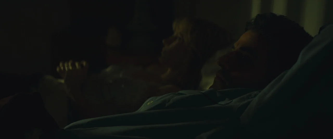 A Most Violent Year (2014) movie still: medium — A dark bedroom with two people lying in bed side-by-side. The man and woman are awake and staring…