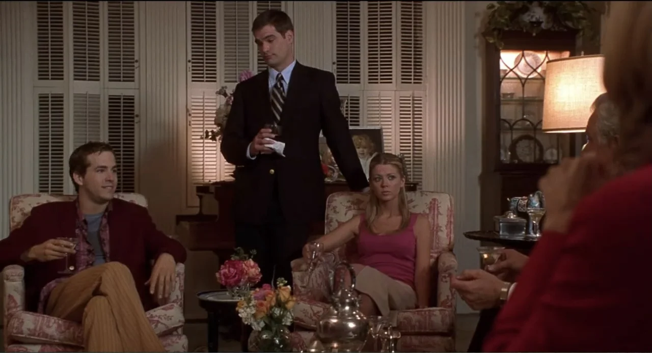 National Lampoon's Van Wilder (2002) movie still: medium — A well-lit living room contains floral-patterned armchairs and a vintage china cabinet.…