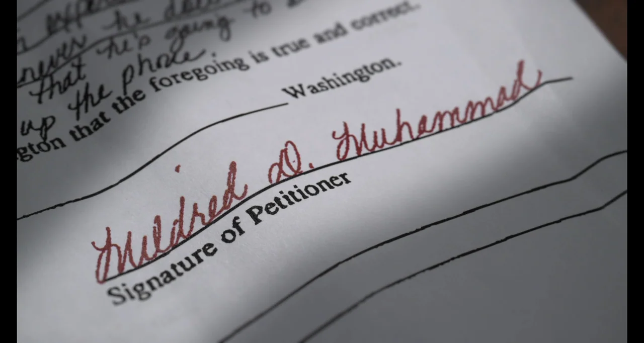 Hunted by My Husband: The Untold Story of the DC Sniper (2025) movie still: closeup — A close-up view of a legal document lying on a flat surface.…