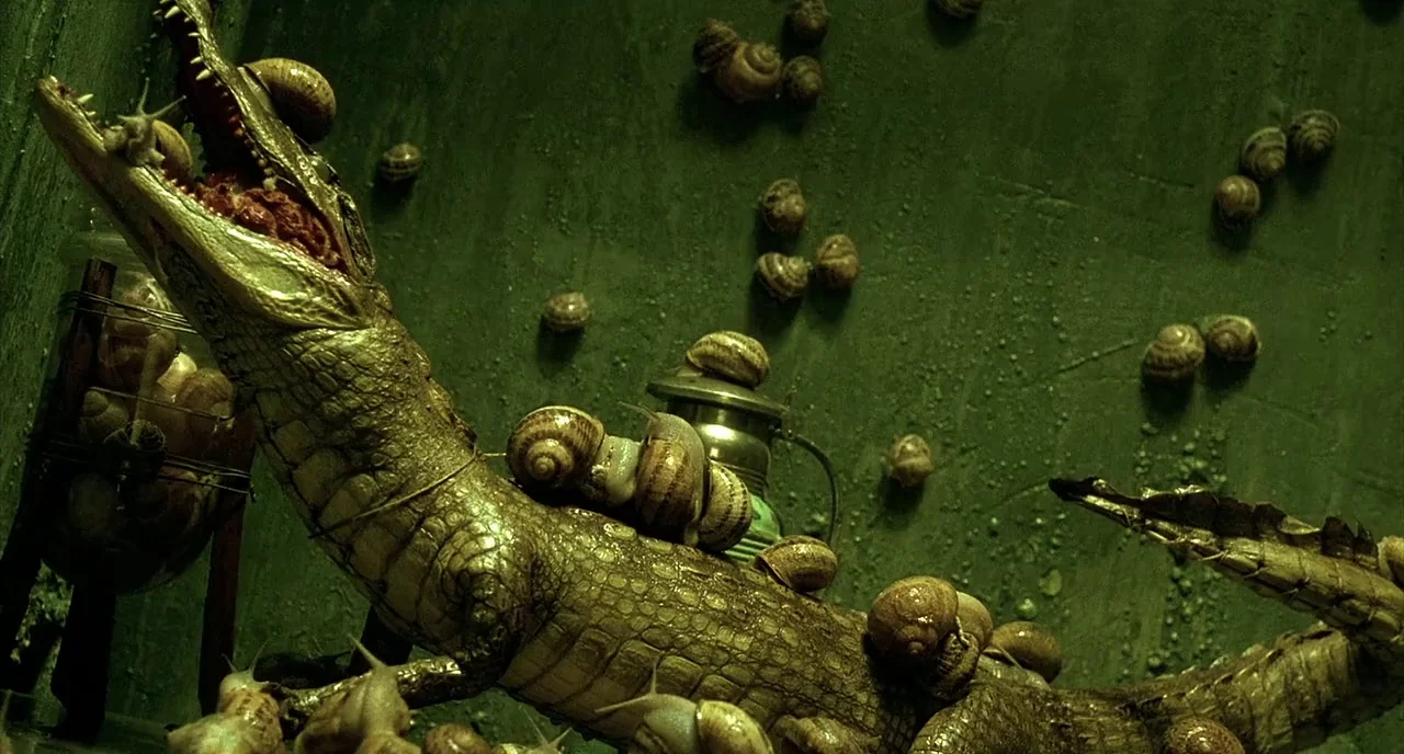 Delicatessen (1991) movie still: medium — A dark, textured enclosure features green-tinted walls covered in multiple small crawling snails. A large…