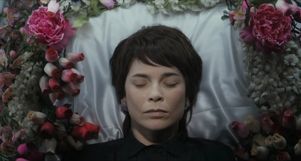 I Killed My Mother (J’ai tué ma mère) (2009) movie still: closeup — The interior of a lined casket contains an adult female resting amidst flowers.…