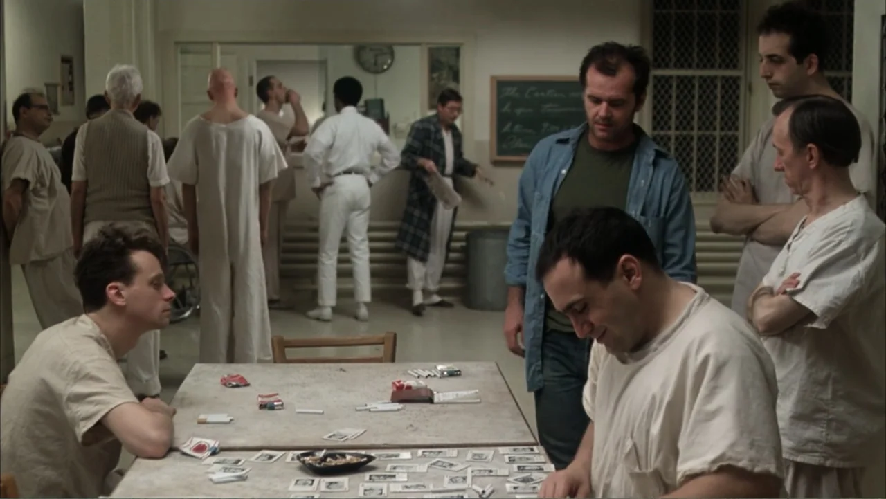 One Flew Over the Cuckoo's Nest (1975) movie still: medium — A linoleum-floored hospital dayroom features patients in white uniforms near a central…