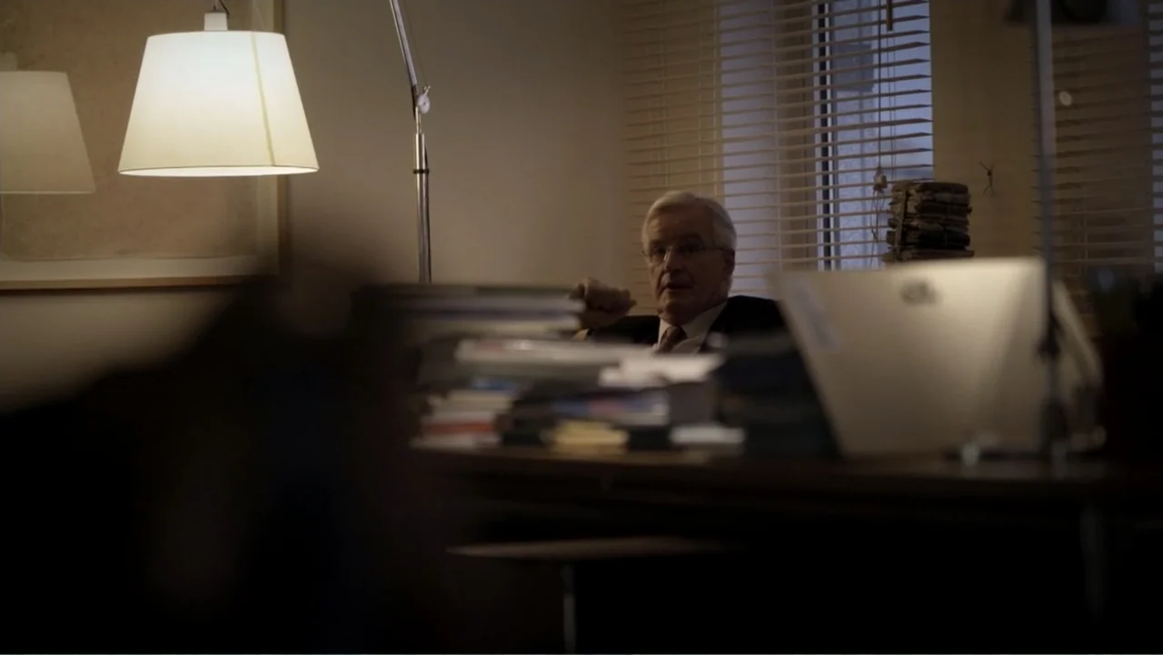 Brexit: Behind Closed Doors (2019) movie still: medium — An office at night contains a large desk covered in stacks of papers and books. An elderly…