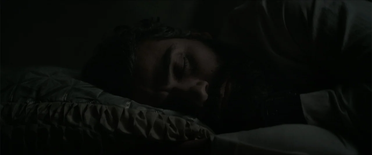 Dune (2021) movie still: closeup — A dimly lit room at night featuring a person sleeping in a bed. The subject lies horizontally with their head…