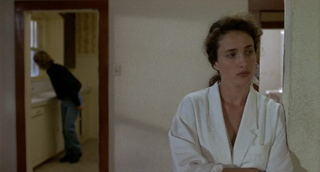 Sex, Lies And Videotape movie still: medium — An interior space features a woman in a white blazer standing in the foreground. A man stands in the…