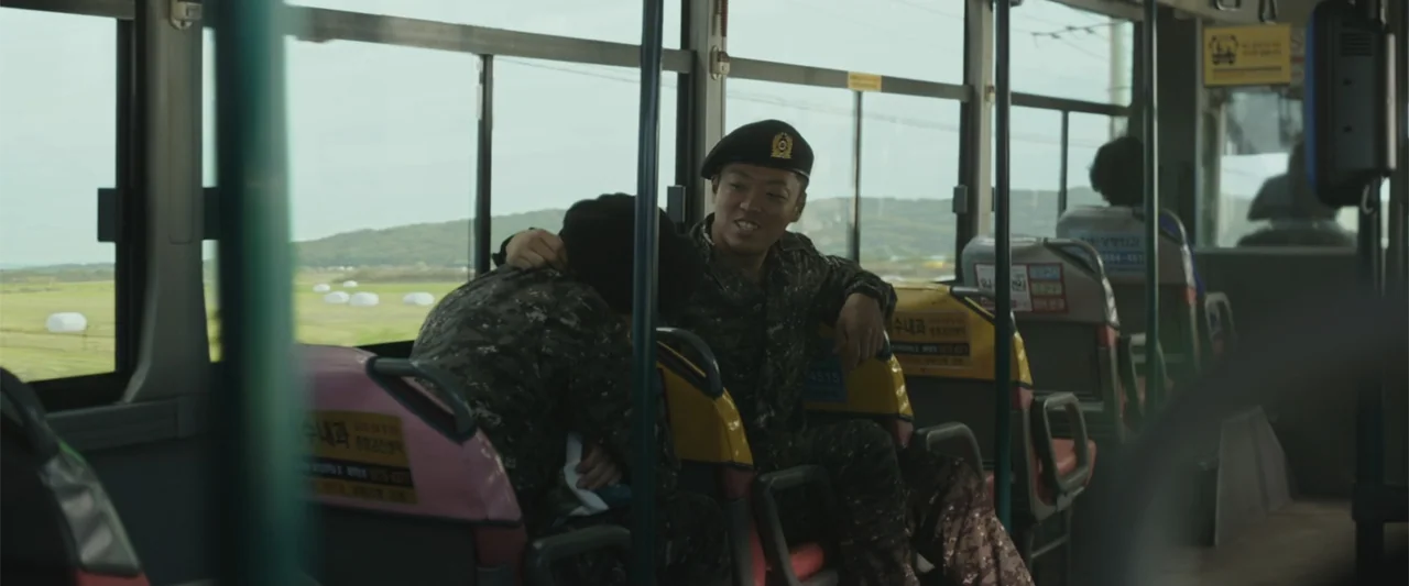Along with the Gods: The Two Worlds (2017) movie still: medium — The interior of a moving public bus during the day with green hills outside. Two…