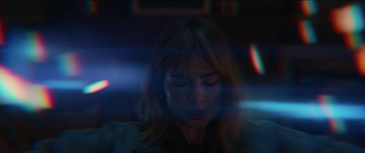 The Greatest Hits (2024) movie still: closeup — A dimly lit interior space with a subject centered in the frame. A woman with closed eyes is…