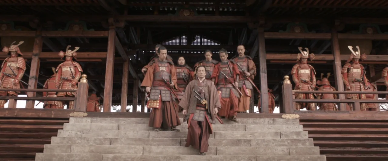 47 Ronin (2013) movie still: fullbody — A group of men in traditional Japanese armor descend a wide outdoor temple staircase. A central figure in…