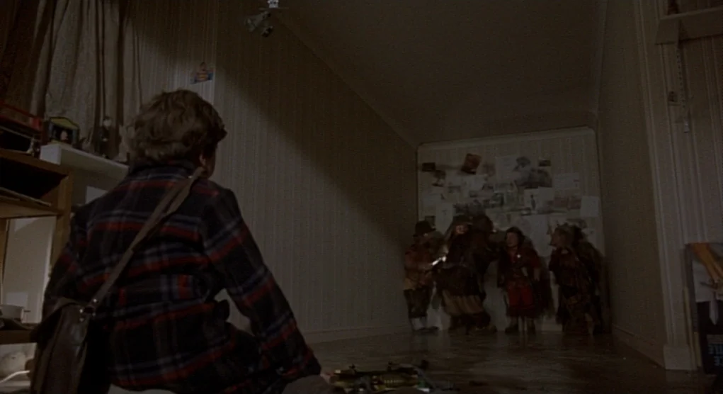 Time Bandits (1981) movie still: medium — A dimly lit room with wallpaper features a small boy looking toward the wall. Four short, armored figures…