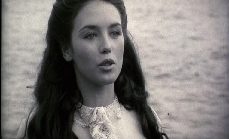 The Story of Adele H (1975) movie still: closeup — A woman stands before a body of water with a blurred, shimmering surface behind. She looks to the…
