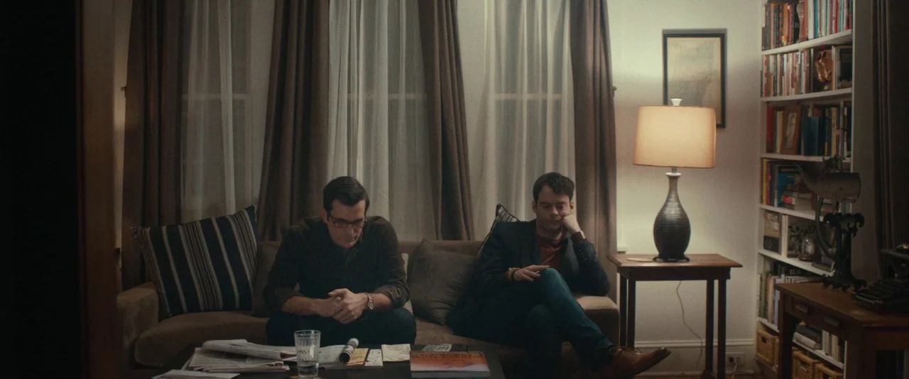 The Skeleton Twins (2014) movie still: wide — A quiet residential room features a couch centered before two windows with heavy curtains. Two men sit…