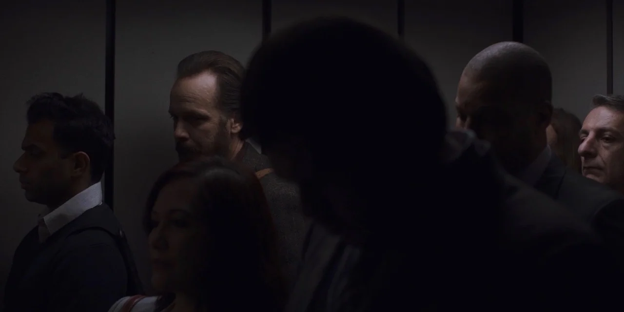 The Sound of Silence movie still: medium — A crowded interior elevator featuring several people standing in a row against a wall. The subjects wait…
