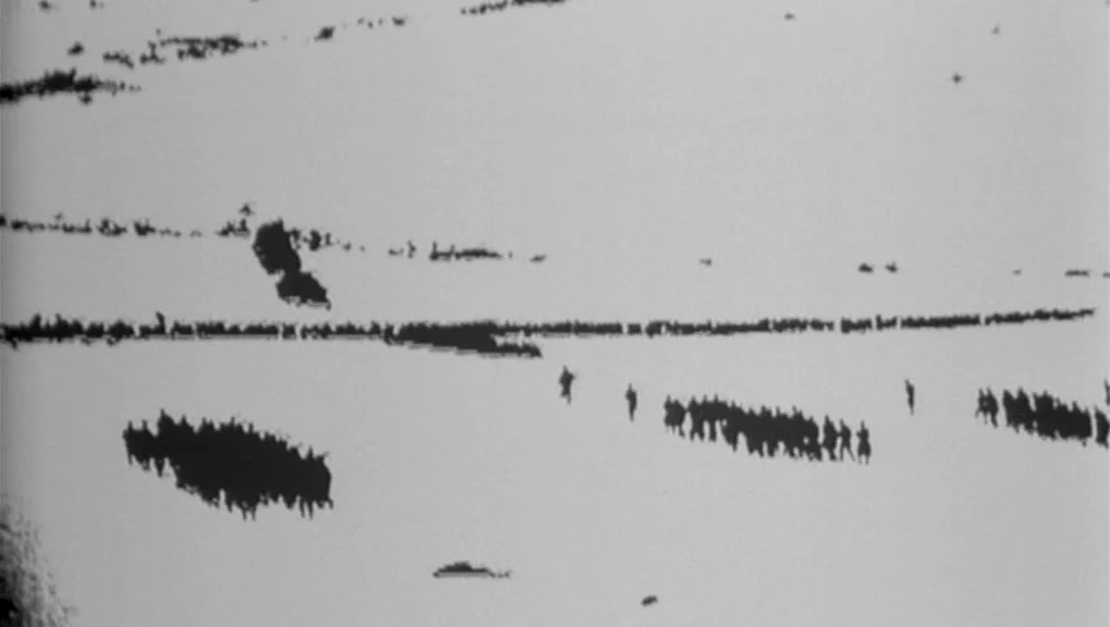 War Requiem (1989) movie still: establishing — A vast, flat, snow-covered expanse with minimal horizon detail. Multiple small groups of dark…