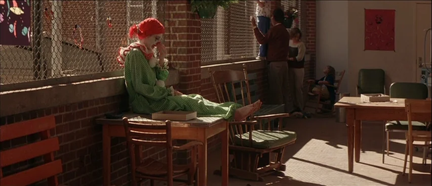 All The Real Girls (2003) movie still: wide — A hospital solarium with red brick walls features a chain-link wall overlooking the exterior. A…