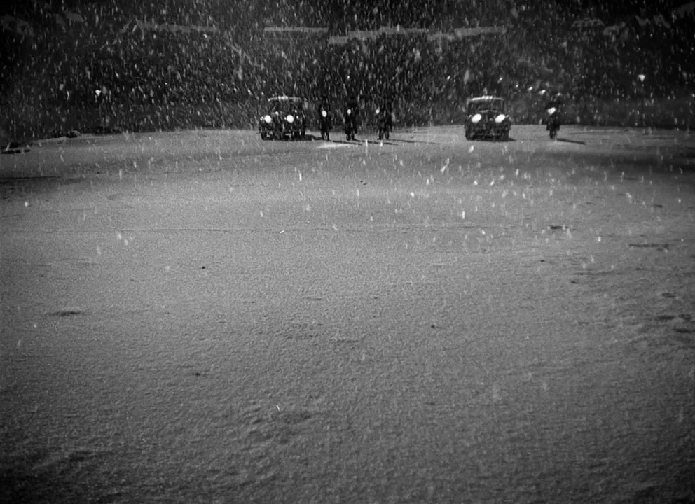 Odd Man Out (1947) movie still: wide — Two cars are parked in an open expanse during a heavy nighttime downpour. The headlights of the vehicles…