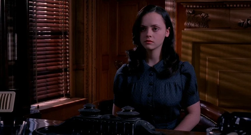 The Man Who Cried (2000) movie still: medium — A dark wood-paneled room features a mahogany desk with a prominent black inkwell stand. A young woman…