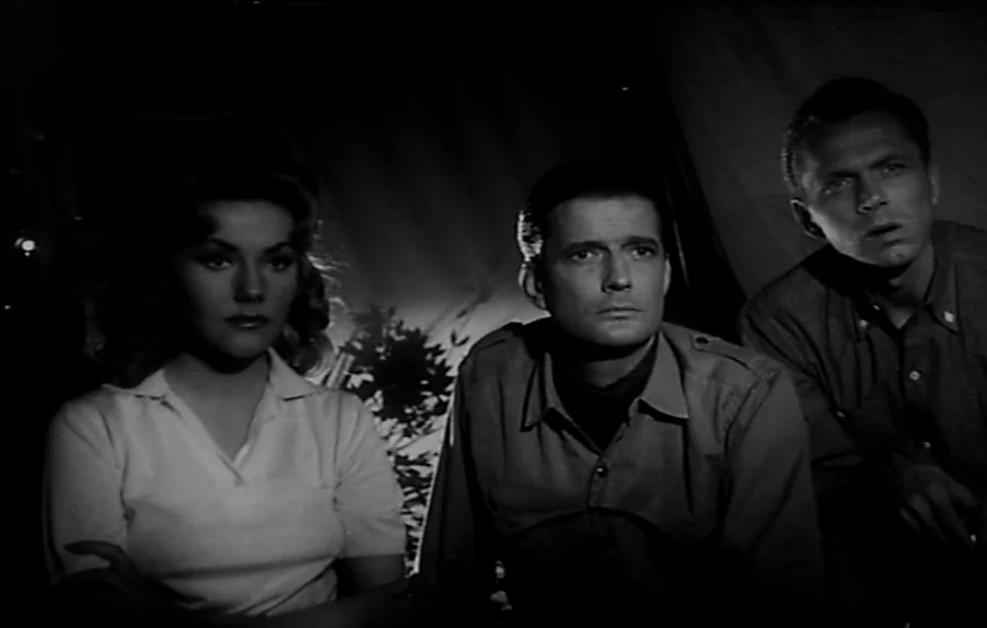 Caltiki, The Immortal Monster (1959) movie still: medium — A dark interior setting with canvas fabric walls visible in the background shadows. Two…