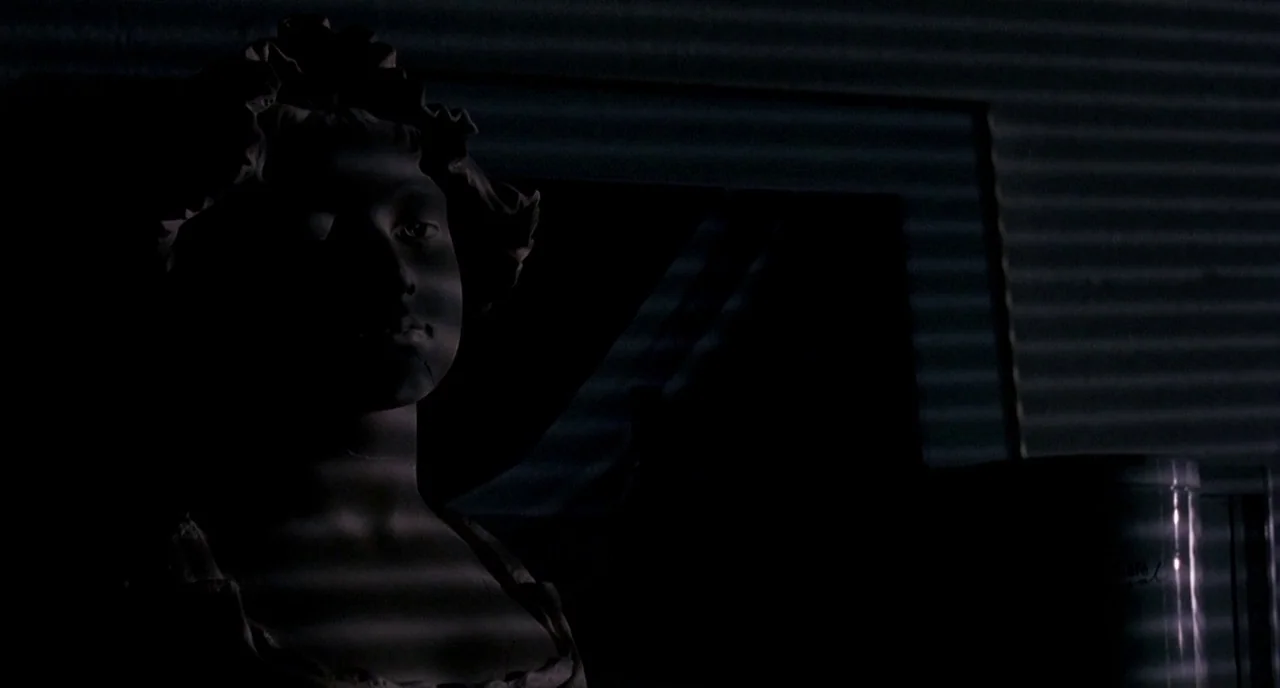 Three Colours: White (1994) movie still: closeup — A dark space contains a marble statue bust illuminated by light through blinds. The statue is…