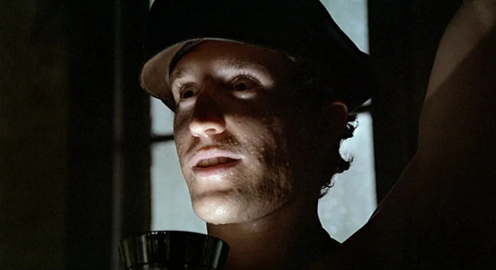 All That Jazz (1979) movie still: closeup — A dimly lit, narrow space features a man standing in front of a window. The man stares forward with a…