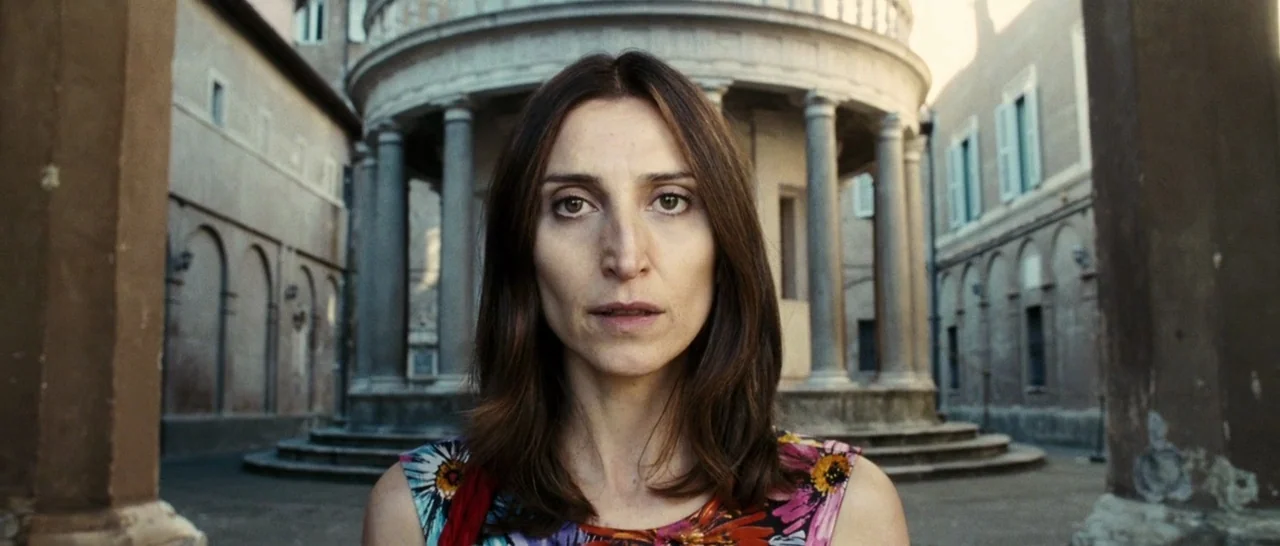The Great Beauty (2013) movie still: closeup — A stone courtyard features a circular temple structure with classical columns in the background. A…