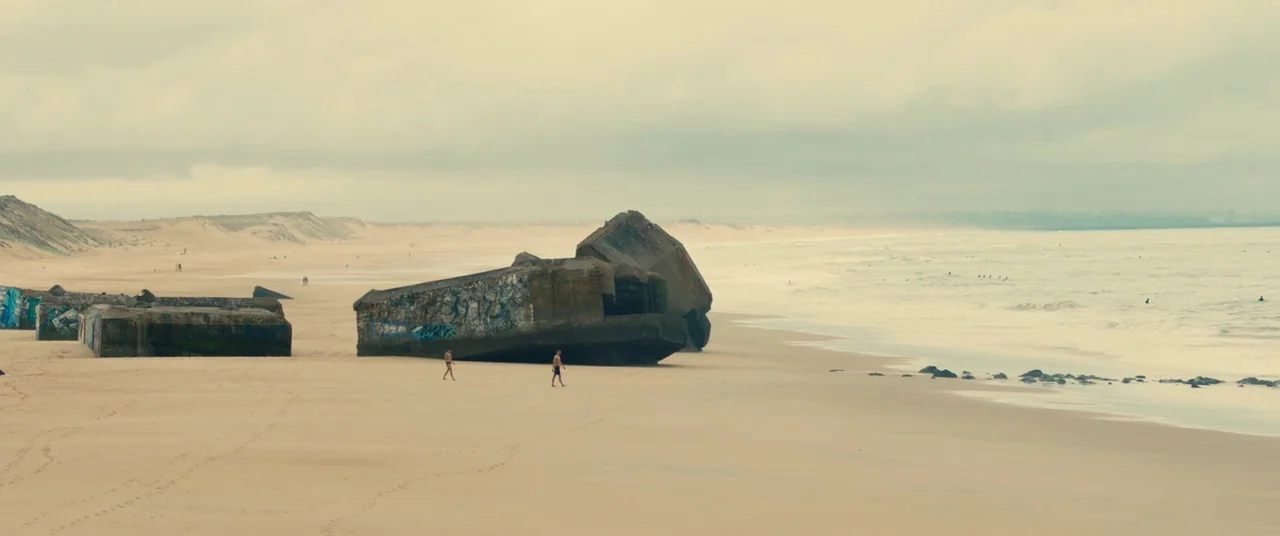 BPM (Beats Per Minute) (2017) movie still: wide — An expansive sandy beach features several massive, graffiti-covered concrete bunkers from the…