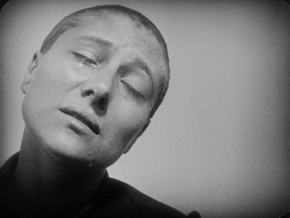The Passion of Joan of Arc (1928) movie still: closeup — A plain, light-colored backdrop defines the space behind a close-up of a face. A person…