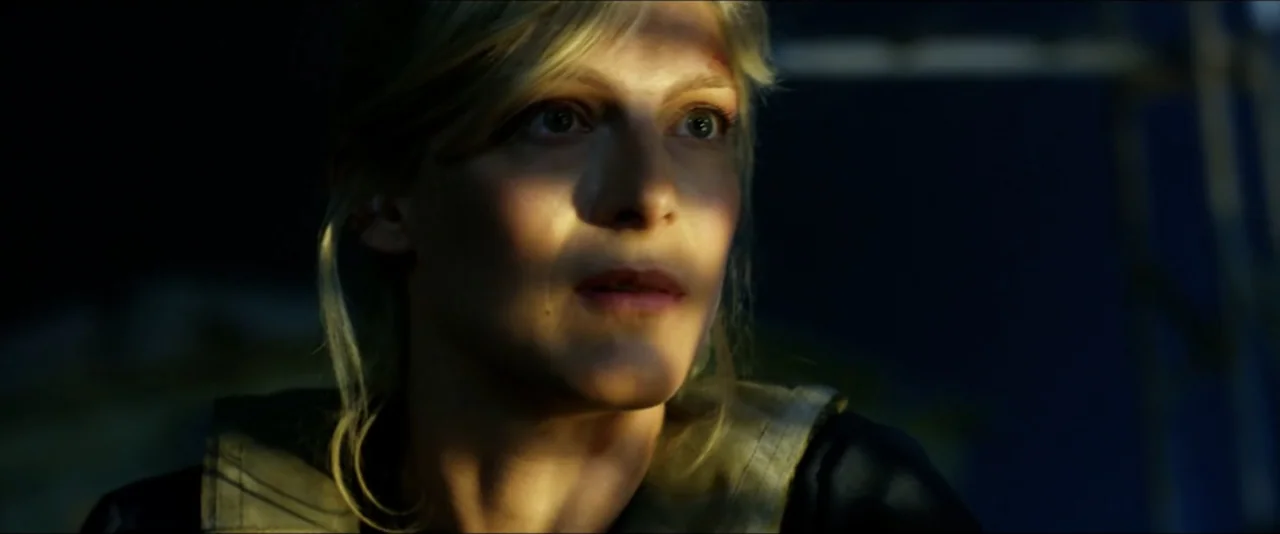 13 Hours: The Secret Soldiers of Benghazi (2016) movie still: closeup — A woman stands in a low-light outdoor environment during the golden hour.…